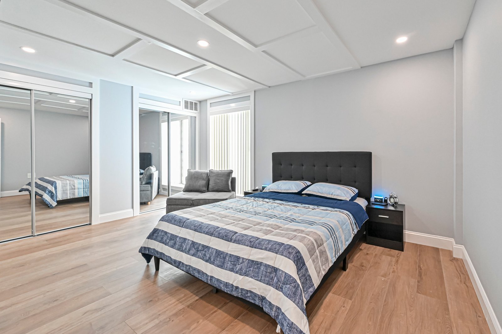 Bedroom with LVP flooring and coffered ceiling