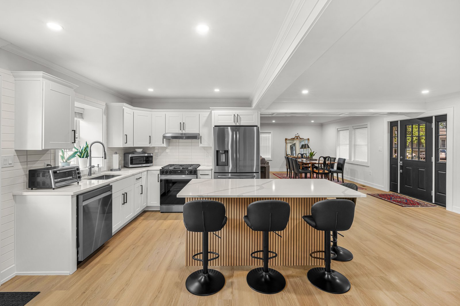 White kitchen with quartz island and LVP flooring